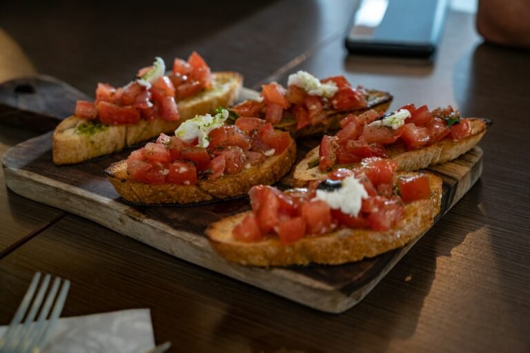 Crostini with tomato served on a wooden board